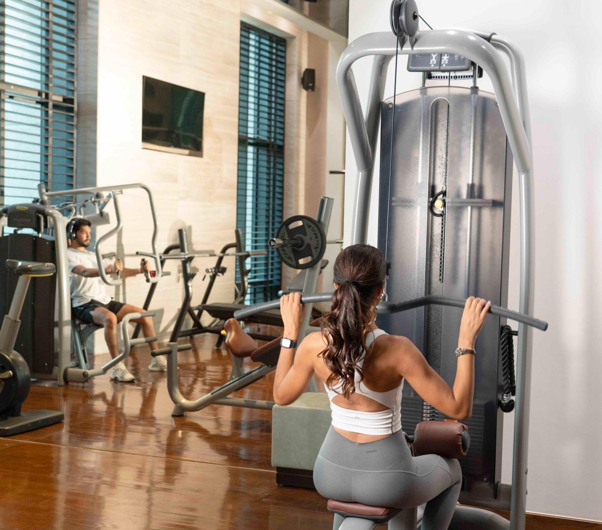 فندق فيرمونت الرياض المظهر الخارجي الصورة A woman using a lat pulldown machine